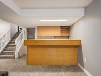Step into this inviting basement featuring a spacious bar area perfect for entertaining.