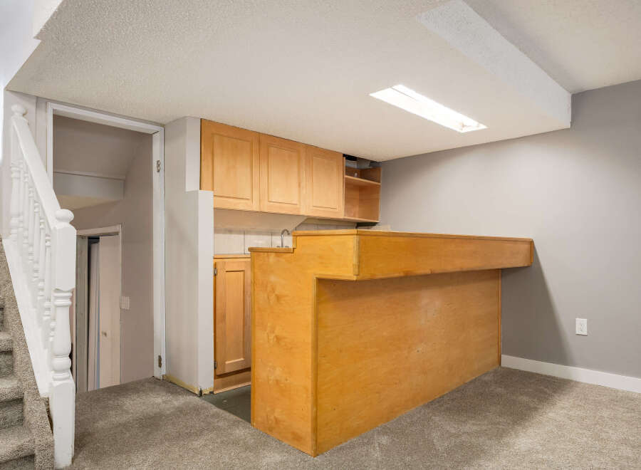 This basement features a convenient wet bar area with ample cabinet space and a built-in counter, perfect for entertaining.