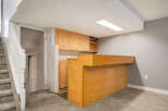 This basement features a convenient wet bar area with ample cabinet space and a built-in counter, perfect for entertaining.