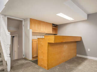 This basement features a convenient wet bar area with ample cabinet space and a built-in counter, perfect for entertaining.
