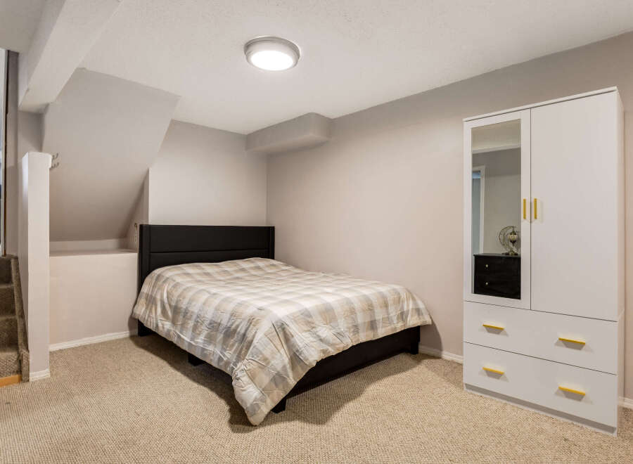 This cozy bedroom features a comfortable bed with a plaid comforter, perfect for a restful night's sleep.