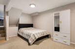 This cozy bedroom features a comfortable bed with a plaid comforter, perfect for a restful night's sleep.