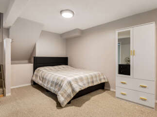 This cozy bedroom features a comfortable bed with a plaid comforter, perfect for a restful night's sleep.