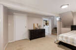 Discover comfortable living in this basement bedroom, featuring a plush carpeted floor and a convenient dresser for storage.