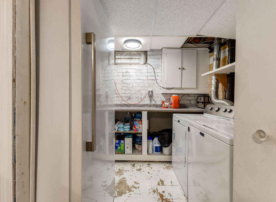 This basement laundry room features a white Maytag washer and dryer, perfect for handling your household chores.