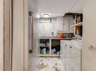 This basement laundry room features a white Maytag washer and dryer, perfect for handling your household chores.