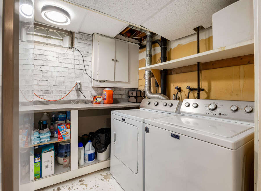 This laundry room features a Maytag washer and dryer set, perfect for handling your household chores.