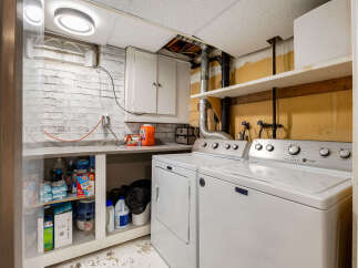 This laundry room features a Maytag washer and dryer set, perfect for handling your household chores.
