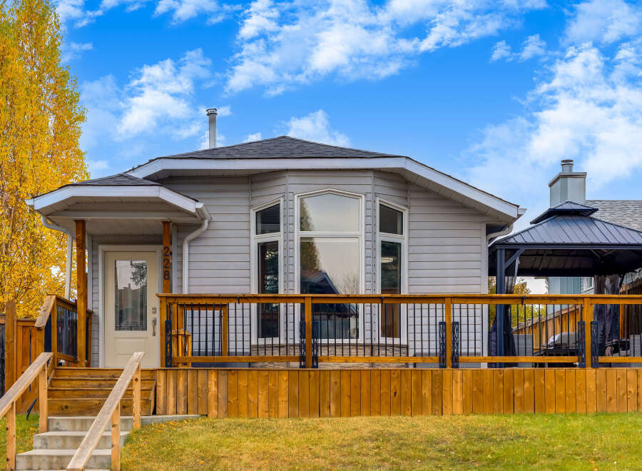 Charming single-family home featuring a spacious wooden deck perfect for outdoor entertaining.