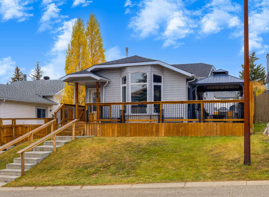 This charming home features a spacious wooden deck perfect for outdoor entertaining, complete with a covered gazebo area.