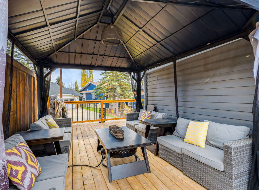 Experience outdoor living at its finest under this spacious gazebo, featuring comfortable seating and a built-in fire pit for cozy evenings.