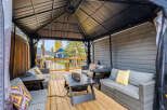 Experience outdoor living at its finest under this spacious gazebo, featuring comfortable seating and a built-in fire pit for cozy evenings.
