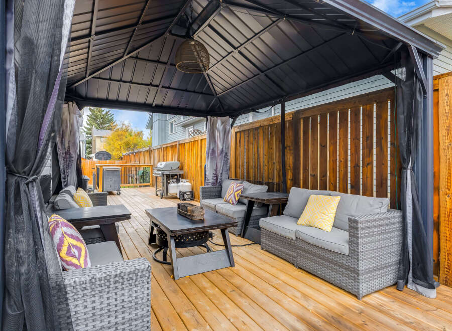 This spacious backyard features a covered gazebo with comfortable outdoor seating, perfect for entertaining guests or enjoying a quiet evening.