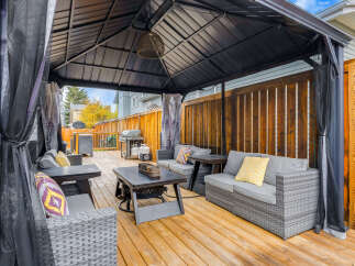 This spacious backyard features a covered gazebo with comfortable outdoor seating, perfect for entertaining guests or enjoying a quiet evening.