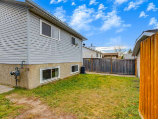 Discover this charming home featuring a well-maintained exterior with light gray vinyl siding and a stucco-finished foundation.