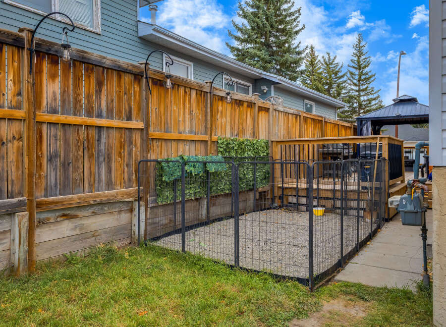 This backyard features a spacious wooden deck with a gazebo, perfect for outdoor entertaining.