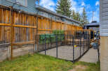 This backyard features a spacious wooden deck with a gazebo, perfect for outdoor entertaining.