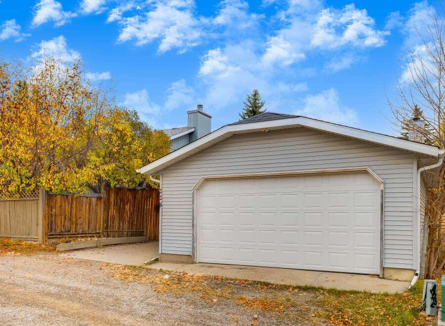 This property features a detached garage with a classic white sectional door, perfect for protecting your vehicles.