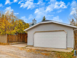 This property features a detached garage with a classic white sectional door, perfect for protecting your vehicles.