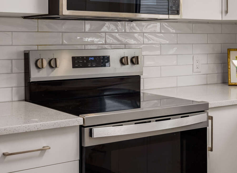 This modern kitchen features a sleek stainless steel range with a smooth glass cooktop, perfect for any home chef.