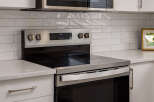 This modern kitchen features a sleek stainless steel range with a smooth glass cooktop, perfect for any home chef.