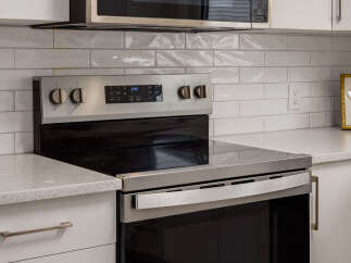 This modern kitchen features a sleek stainless steel range with a smooth glass cooktop, perfect for any home chef.