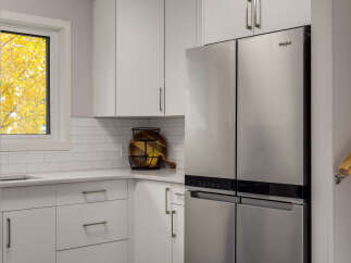 This modern kitchen features sleek white subway tile backsplash and light gray cabinetry, creating a bright and airy atmosphere.