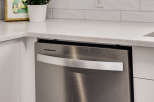 Discover a modern kitchen featuring a sleek stainless steel dishwasher integrated seamlessly with white cabinetry.