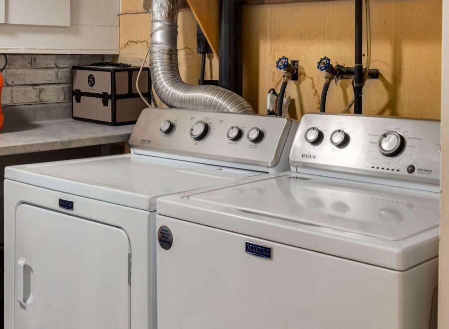 This laundry room features a Maytag washer and dryer set, perfect for handling all your laundry needs.