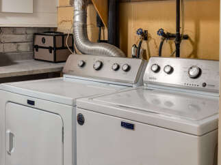 This laundry room features a Maytag washer and dryer set, perfect for handling all your laundry needs.