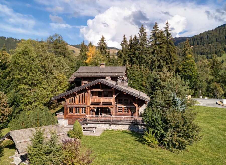 Nestled amidst lush greenery and towering trees, this magnificent wooden chalet offers a serene mountain retreat.