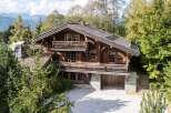 Experience the charm of this rustic wooden chalet nestled amidst lush greenery and majestic mountains.