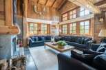 Experience rustic luxury in this stunning mountain lodge living room, featuring a grand stone fireplace and exposed wooden beams.