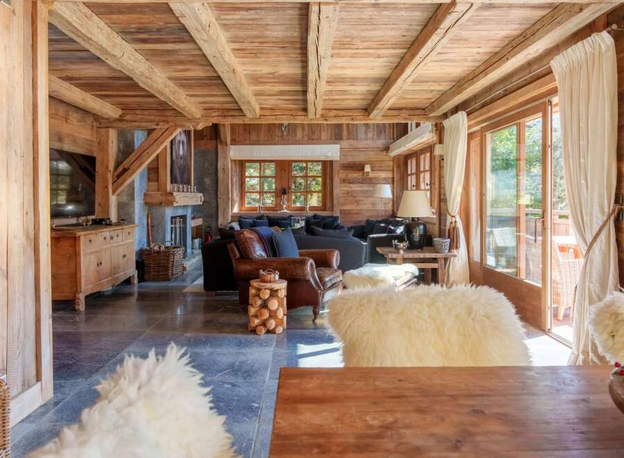 Experience rustic luxury in this charming mountain chalet, featuring exposed wooden beams and a cozy stone fireplace.