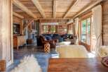 Experience rustic luxury in this charming mountain chalet, featuring exposed wooden beams and a cozy stone fireplace.