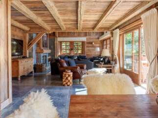 Experience rustic luxury in this charming mountain chalet, featuring exposed wooden beams and a cozy stone fireplace.