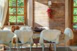 Experience rustic charm in this dining room, featuring a striking antler chandelier and cozy sheepskin-covered chairs.