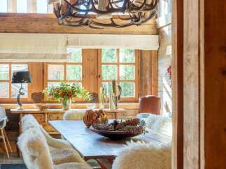 Experience rustic elegance in this charming dining room, featuring a magnificent antler chandelier that casts a warm glow.