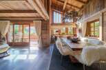 Experience rustic luxury in this stunning dining room, featuring a grand wooden table adorned with plush, sheepskin-covered chairs, perfect for intimate gatherings.
