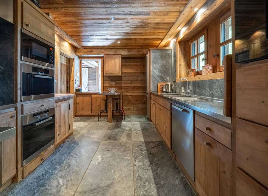 Experience rustic charm in this beautifully appointed wooden kitchen, featuring modern Miele appliances including a built-in oven and microwave.