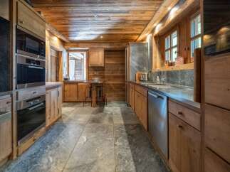 Experience rustic charm in this beautifully appointed wooden kitchen, featuring modern Miele appliances including a built-in oven and microwave.