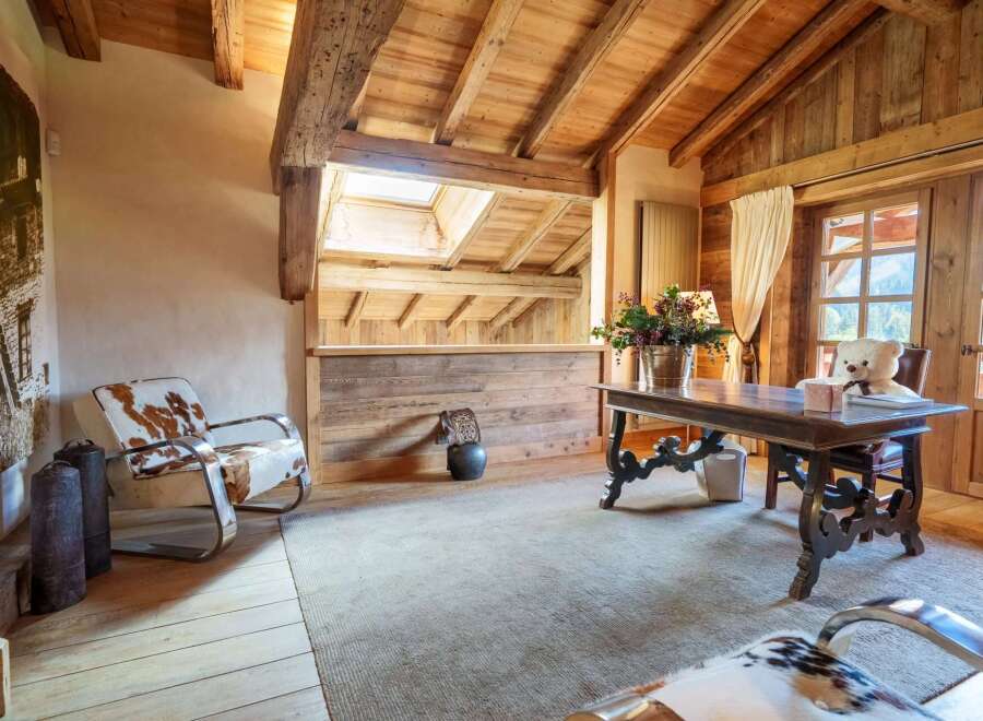 Experience rustic charm and modern comfort in this beautifully appointed room, featuring exposed wooden beams and a vaulted ceiling.