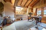 Experience rustic charm and modern comfort in this beautifully appointed room, featuring exposed wooden beams and a vaulted ceiling.