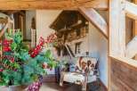 Experience rustic charm in this mountain retreat, featuring exposed wooden beams and a cozy armchair upholstered in cowhide.