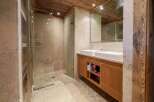 Experience rustic luxury in this stunning bathroom, featuring a spacious walk-in shower with stone tile walls and a pebble floor.