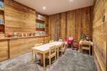 This charming children's playroom features rustic wooden walls and built-in shelving, creating a warm and inviting atmosphere.