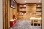 This charming children's playroom features a rustic wooden wall and a cozy grey carpet, creating a warm and inviting atmosphere.