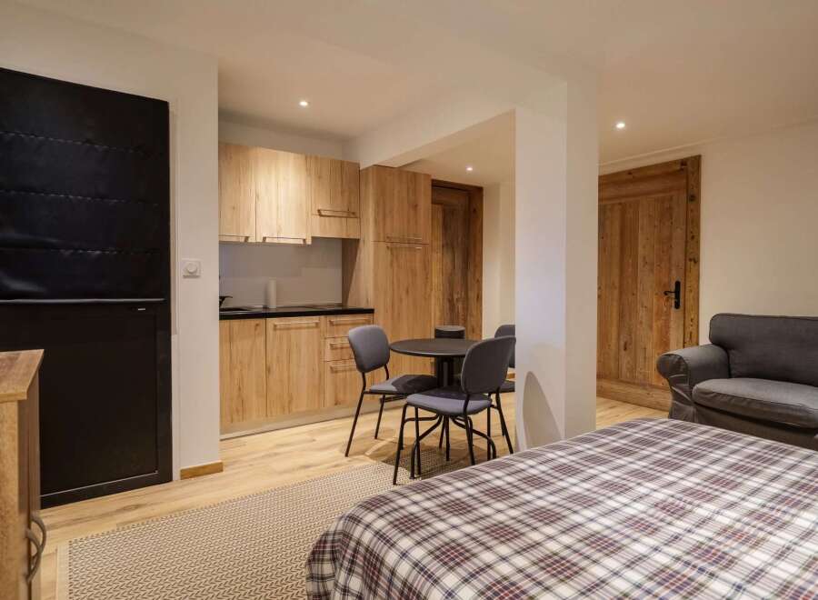 This charming studio apartment features a modern kitchenette with light wood cabinetry, perfect for preparing meals.