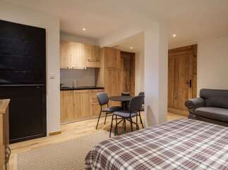 This charming studio apartment features a modern kitchenette with light wood cabinetry, perfect for preparing meals.