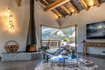 Experience breathtaking mountain views from this luxurious living room, featuring a modern fireplace and a sleek chaise lounge.